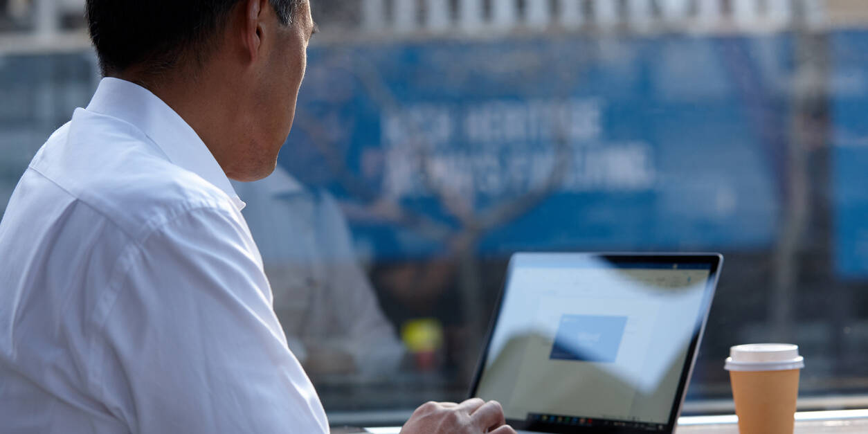 Australasian businessman working on laptop outside