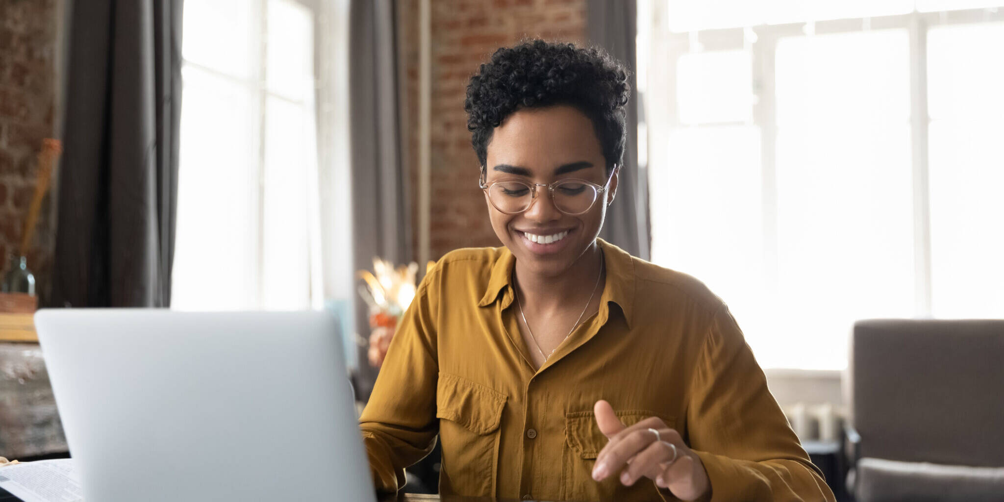 Happy young Afro American entrepreneur woman in glasses counting profit