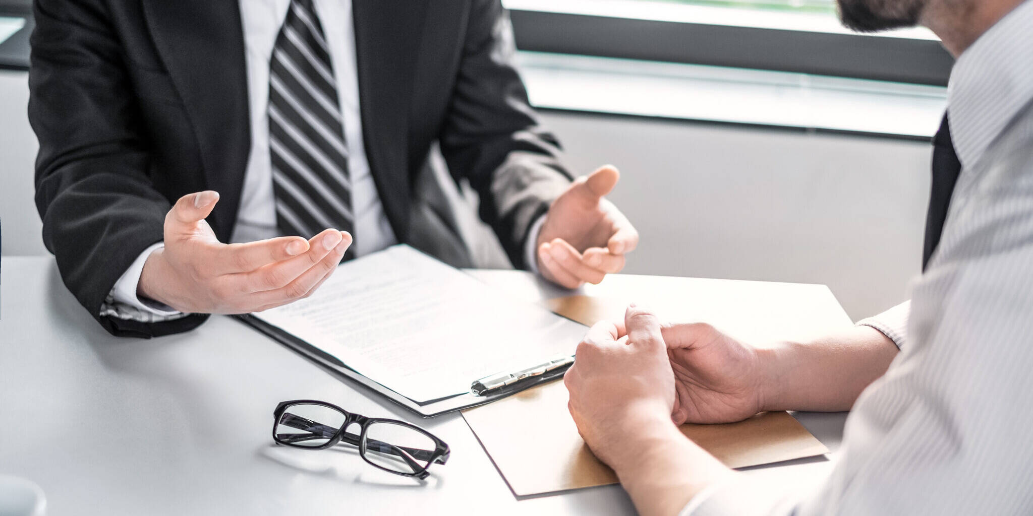 Business people negotiating a contract. Human hands working with documents at desk and signing contract.